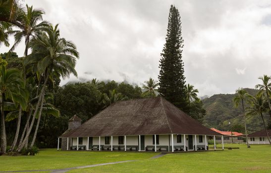 The old Waioli Huiia Mission building and hall in Hanalei Kauai with the Na Pali Mountains shrouded in mist in the background