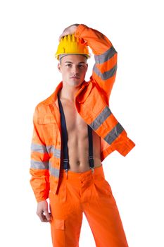 Handsome young construction worker with orange suit open on naked torso, wearing yellow hardhat