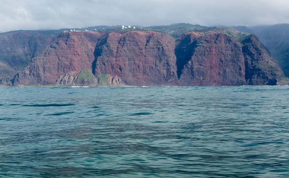 Rugged mountains and cliffs of Na Pali coast in Kauai seen from a cruise boat in winter