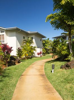 Pathway leads through tropical plants at hotel or timeshare holiday vacation resort