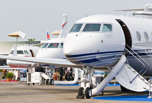 SINGAPORE - FEBRUARY 12: Corporate jets with the Gulfstream G650 in the foreground on display at Singapore Airshow, Changi Exhibition Centre in Singapore on February 12, 2014.