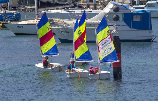 MANLY, AUSTRALIA-DECEMBER 19TH 2013: Children learning the basics of sailing in dinghies in Manly harbour. Sailing is a very popular sport in Australia.