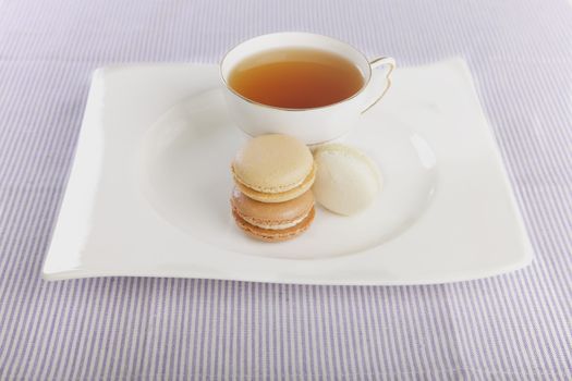 Tea and macaroons displayed on a white plate