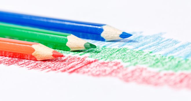 RGB pencils and abstract lines of red, green and blue color on textured paper