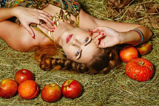 Attractive young rural girl in the hayloft after harvest festival