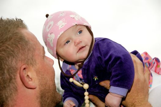 Happy father is lifting up his smiling baby
