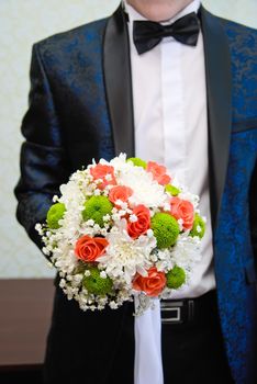 Bridal bouquet in the hand of the groom