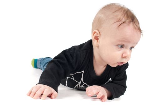Shot of little baby in black top lying on white background