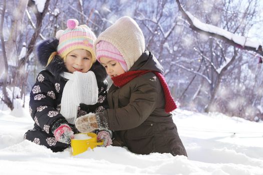 Two happy girls playing in snowy park