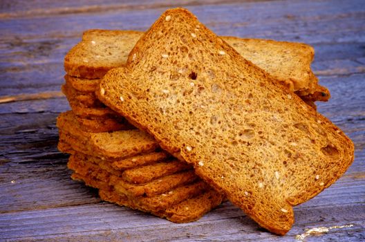 Stack of Whole Wheat Crunchy Dread Slices closeup on Rustic Wooden background