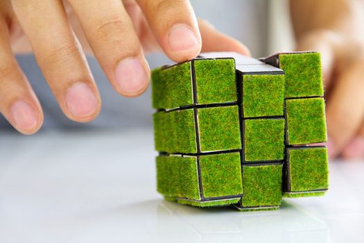 hand holding green rubik's cube concept