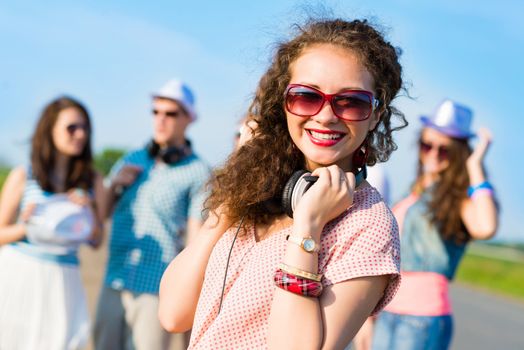 young woman with headphones on a background of blue sky and funny friends