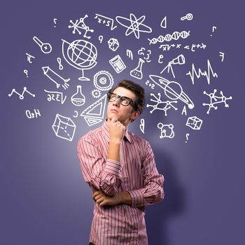 young man scientist in glasses thinking. next to it various painted symbols