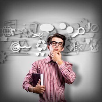 young man scientist in glasses thinking. next to it various painted symbols