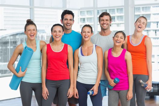 Portrait of fit young people smiling in a bright exercise room