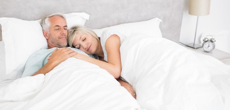 Loving mature man and woman lying in bed at the home