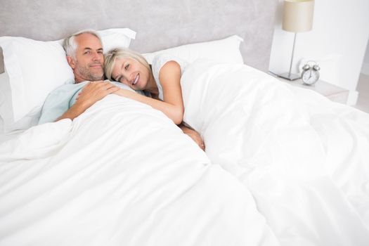 Loving mature man and woman lying in bed at the home