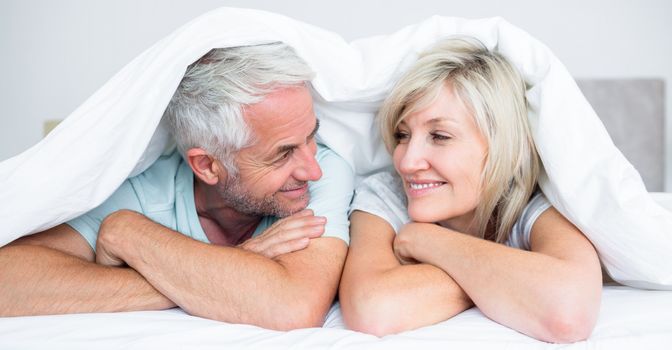 Closeup portrait of a mature couple lying in bed at home