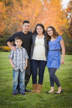 Attractive Hispanic Family Portrait in a Colorful Fall Outdoor Setting At the Park.