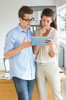 Young business people using tablet PC while standing in office