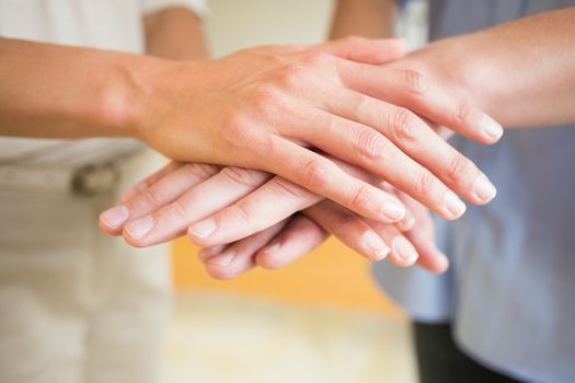 Closeup of business people stacking hands in office