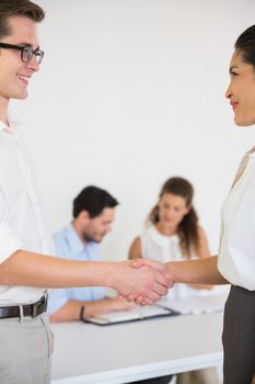 Businessman and businesswoman greeting each other in office meeting