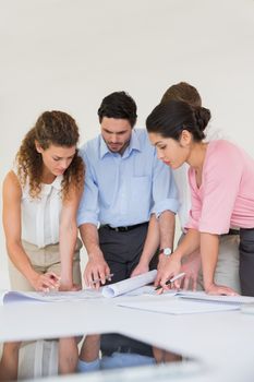 Business people working on blueprint at desk in office