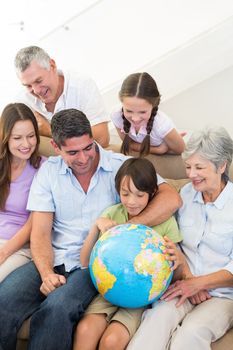 Multigeneration family looking at globe in house