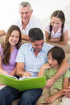 Multigeneration family reading book at home