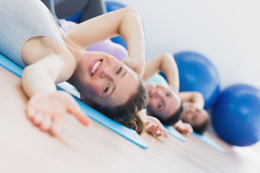 Side view portrait of fit class exercising in row at fitness studio