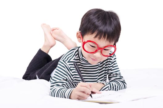 Smart boy learn to write on the bed