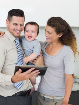 Happy businessman with digital tablet and family at home