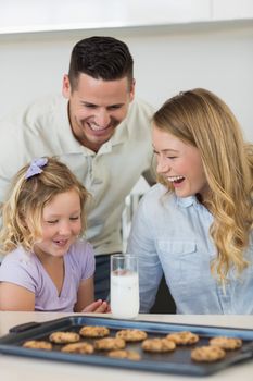 Happy family with milk and cookies at kitchen counter