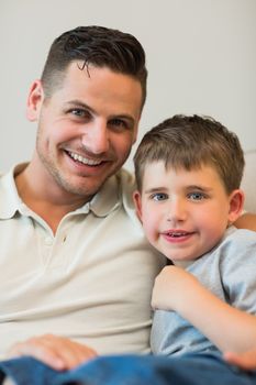 Portrait of father and son smiling together at home