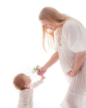 Girl gives snowdrops to pregnant mother, isolated on white