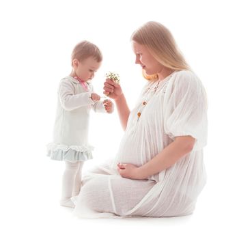 Girl gives snowdrops to pregnant mother, isolated on white