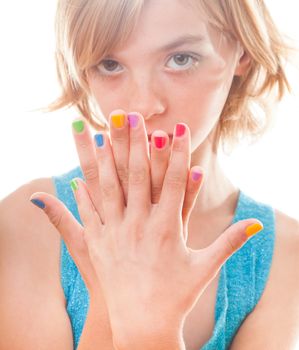 Teenager blonde girl's face with multicoloured nails close up