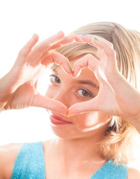 Teenager blonde girl shows heart shape  with multicoloured nails