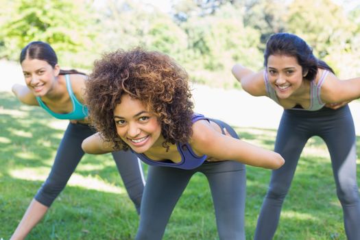 Portrait of smiling sporty women exercising in park