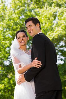 View of a romantic newlywed couple standing in the park