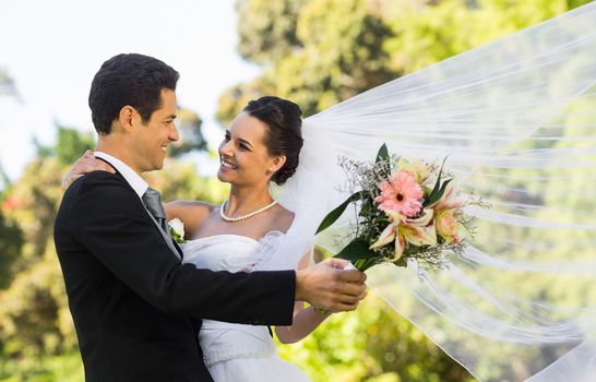 View of a romantic newlywed couple dancing in the park