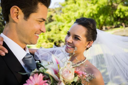 Close-up of a romantic newlywed couple looking at each other in the park