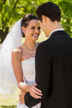 View of a romantic newlywed couple standing in the park