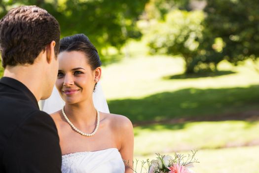 View of a romantic newlywed couple looking at each other in the park