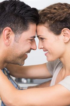 Romantic happy couple hugging at home in kitchen