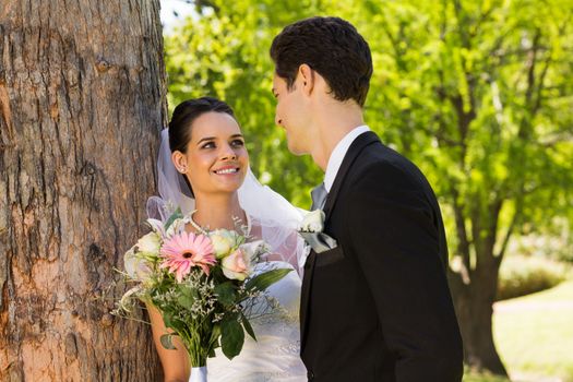 View of a romantic newlywed couple standing in the park