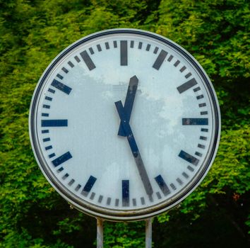 A Grungy Old Clock Against A Green Backdrop