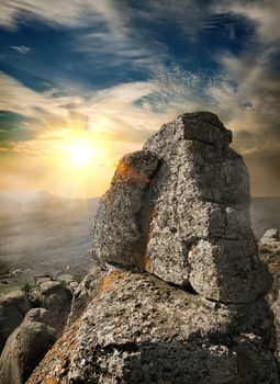 Landscape with rock in mountains at sunset