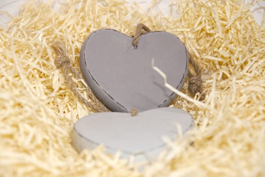 two wooden hearts in a love nest made of straw