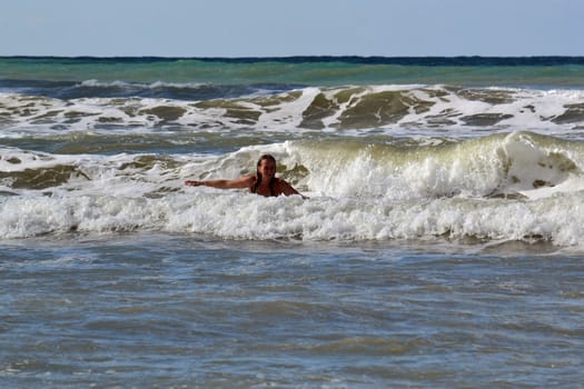The woman in the sea against big waves
